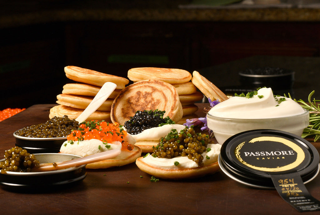 stack of blinis, with creme fraiche, and a variety of caviars and roe, each with their own mother of pearl spoons